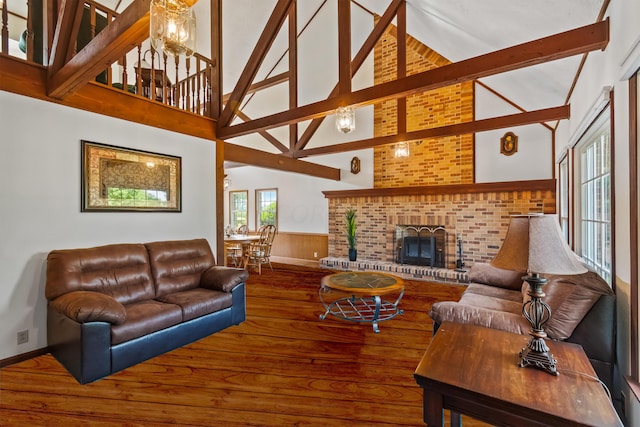 living room featuring beam ceiling, high vaulted ceiling, and a brick fireplace