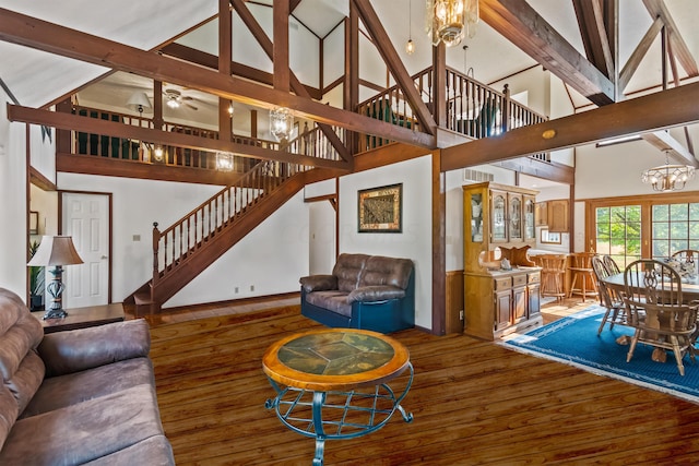 living room featuring hardwood / wood-style floors, ceiling fan with notable chandelier, beamed ceiling, and high vaulted ceiling