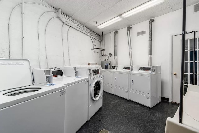 washroom featuring water heater and washing machine and clothes dryer