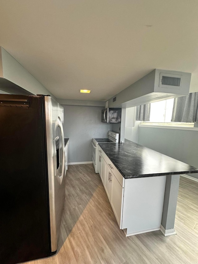 kitchen with kitchen peninsula, white cabinetry, stainless steel appliances, and light wood-type flooring