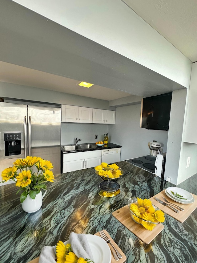 kitchen featuring white cabinets, stainless steel fridge with ice dispenser, white dishwasher, and sink