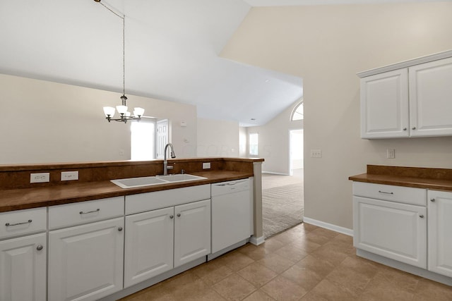 kitchen featuring white cabinetry, dishwasher, sink, hanging light fixtures, and lofted ceiling