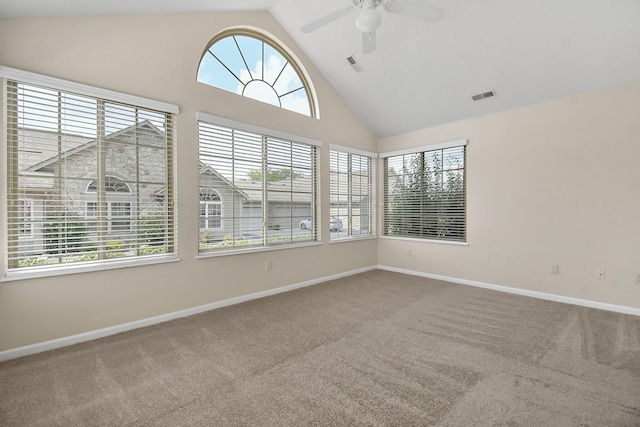 carpeted empty room featuring ceiling fan, plenty of natural light, and high vaulted ceiling