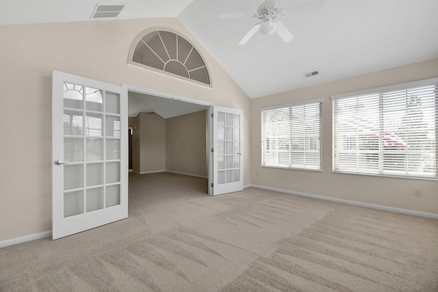 empty room featuring ceiling fan, french doors, light colored carpet, and vaulted ceiling