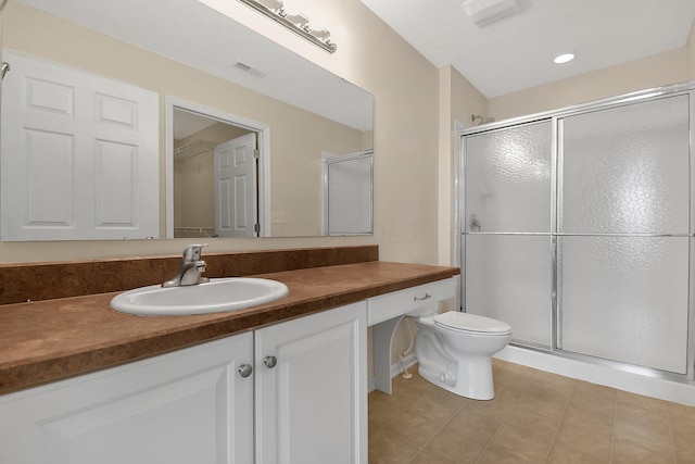 bathroom with tile patterned flooring, vanity, an enclosed shower, and toilet