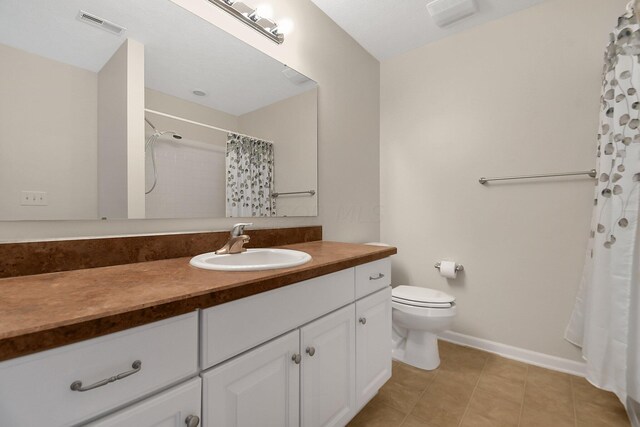 bathroom featuring tile patterned floors, walk in shower, vanity, and toilet