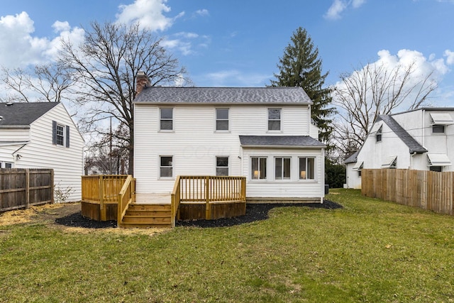 back of property with a yard and a wooden deck