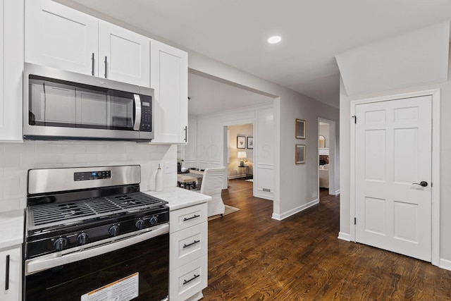 kitchen with white cabinets, stainless steel appliances, and dark wood-type flooring