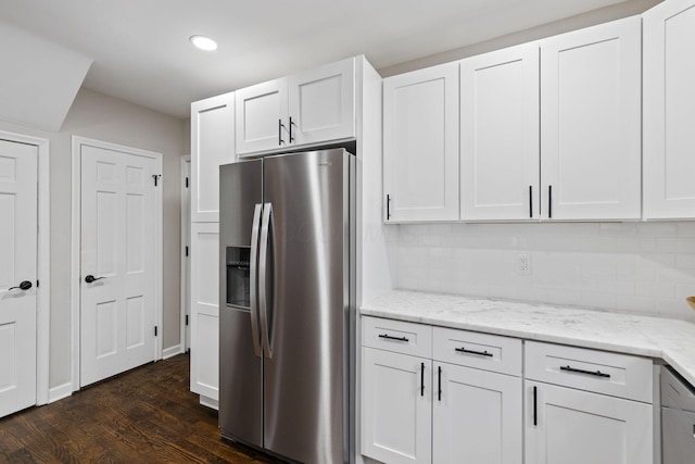 kitchen with light stone countertops, stainless steel fridge, tasteful backsplash, dark wood-type flooring, and white cabinetry