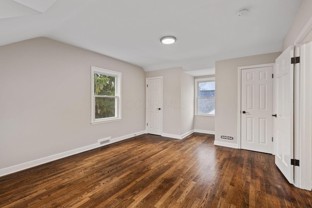 unfurnished bedroom featuring dark hardwood / wood-style floors and vaulted ceiling