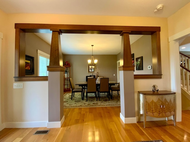 dining room featuring baseboards, stairway, visible vents, and light wood-style floors