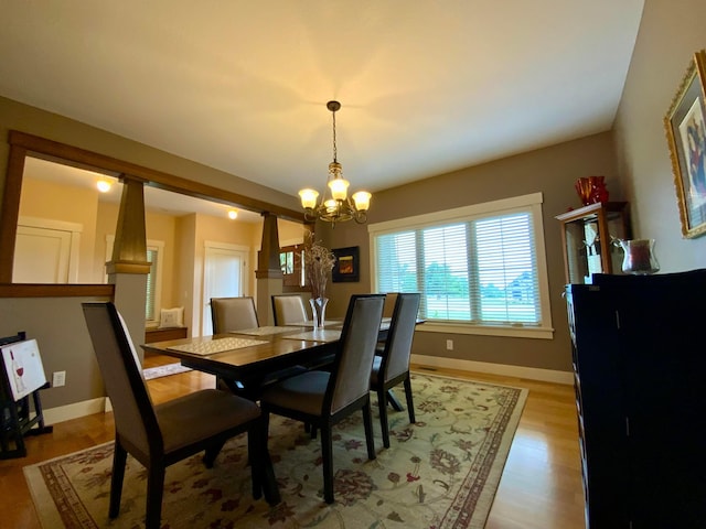 dining room featuring light wood finished floors, baseboards, and a chandelier