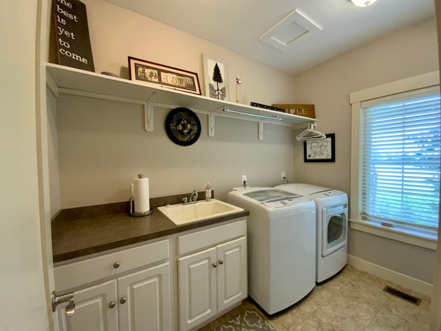 laundry room with a sink, visible vents, baseboards, cabinet space, and washer and clothes dryer