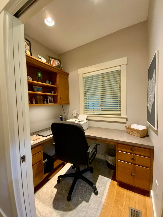 home office with light wood-style floors, recessed lighting, visible vents, and built in study area