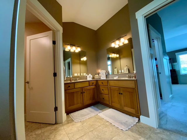 bathroom with tile patterned floors, vanity, and vaulted ceiling