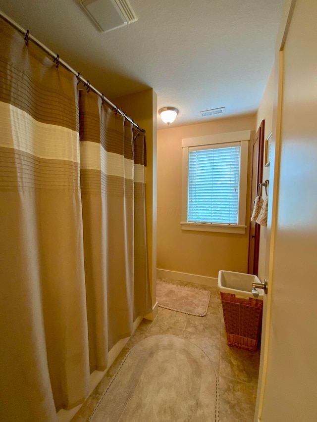 full bath with visible vents and baseboards