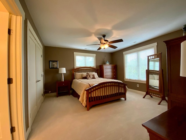 carpeted bedroom featuring multiple windows and ceiling fan