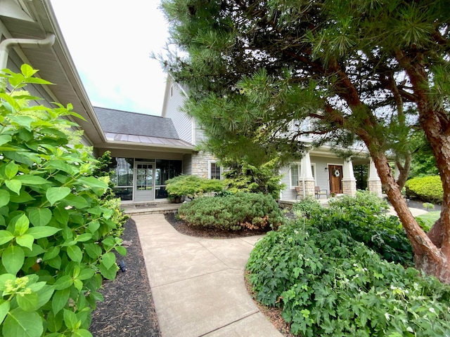 view of front of property with metal roof, stone siding, and a standing seam roof