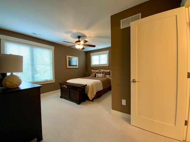 carpeted bedroom featuring visible vents and ceiling fan