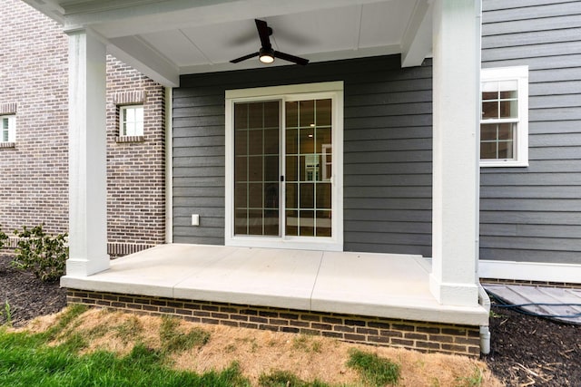 view of exterior entry featuring covered porch and ceiling fan