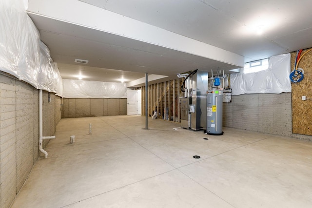 basement with heating unit, water heater, and brick wall