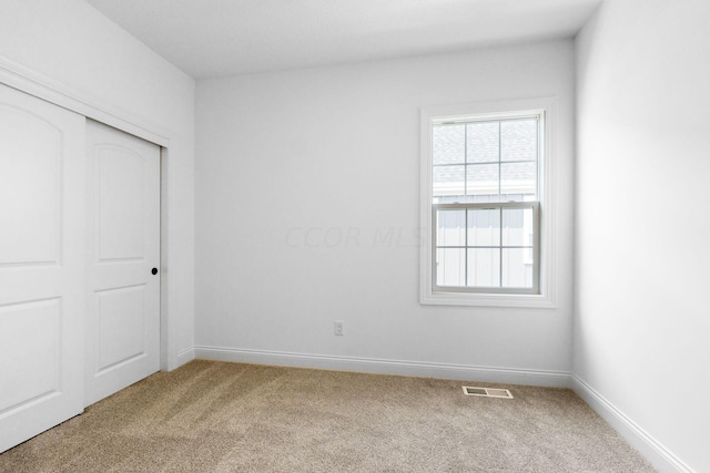 unfurnished bedroom with a closet and carpet floors