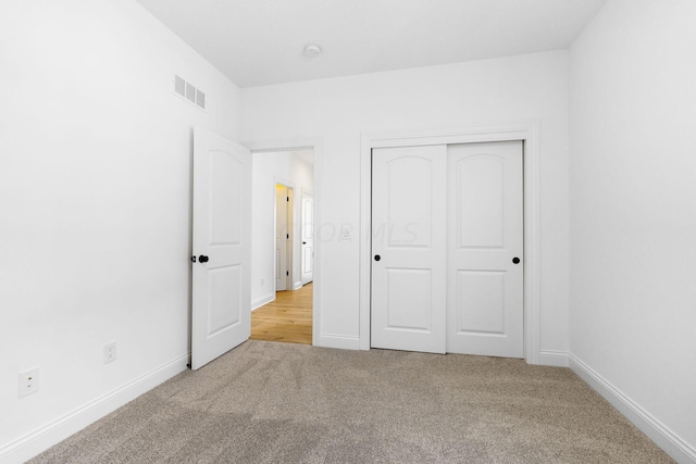 unfurnished bedroom featuring carpet and a closet