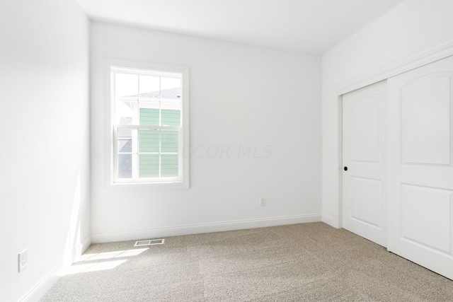 unfurnished bedroom featuring carpet flooring and a closet