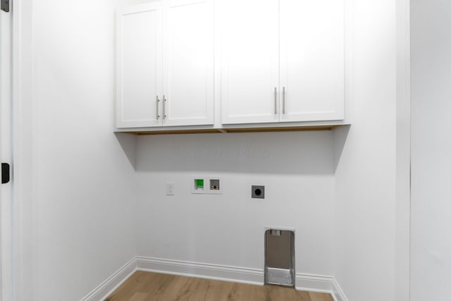 washroom with hookup for an electric dryer, hookup for a washing machine, light wood-type flooring, and cabinets