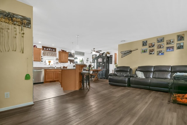 living room with dark hardwood / wood-style floors, ceiling fan, and sink