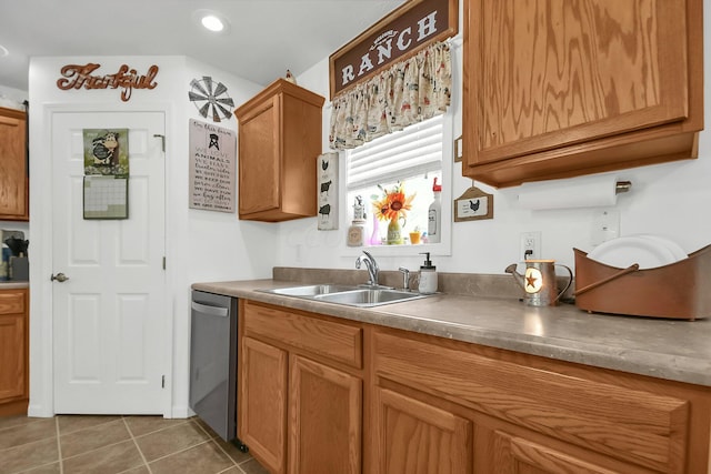 kitchen with stainless steel dishwasher, dark tile patterned floors, and sink