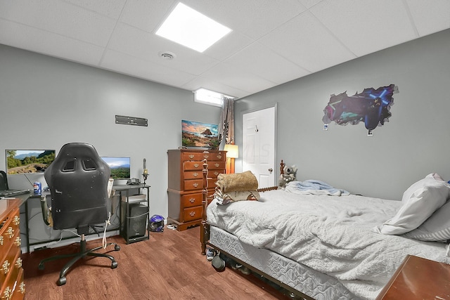 bedroom with hardwood / wood-style flooring and a paneled ceiling