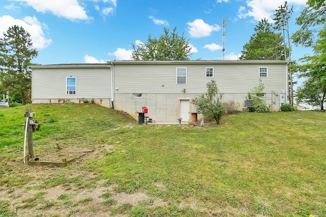 rear view of property featuring a lawn