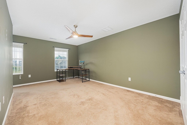 empty room featuring light colored carpet and ceiling fan