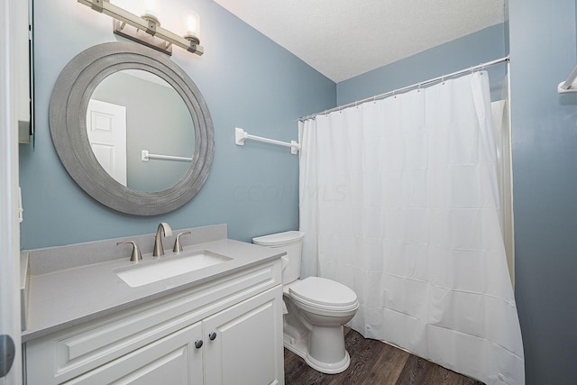 bathroom featuring hardwood / wood-style floors, vanity, a textured ceiling, and toilet