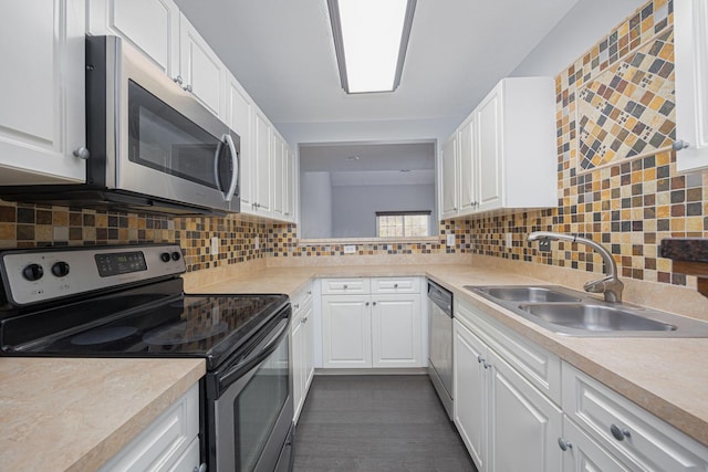 kitchen featuring white cabinets, appliances with stainless steel finishes, backsplash, and sink