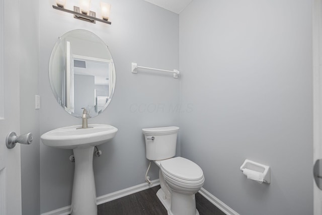 bathroom with hardwood / wood-style flooring and toilet