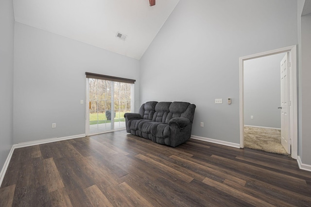 sitting room with high vaulted ceiling and dark wood-type flooring