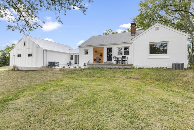 rear view of house featuring a lawn, central air condition unit, and a patio area