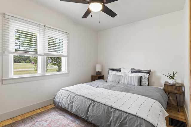 bedroom with ceiling fan and wood-type flooring