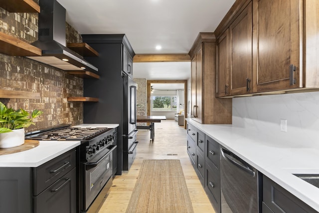 kitchen featuring decorative backsplash, light wood-type flooring, wall chimney exhaust hood, and high quality appliances