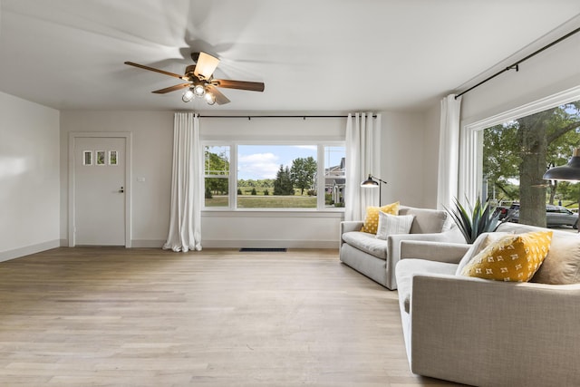 living room with ceiling fan, a healthy amount of sunlight, and light hardwood / wood-style floors