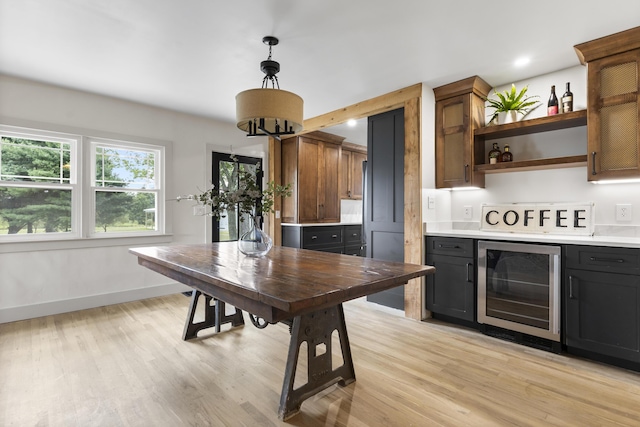 interior space with wine cooler, light hardwood / wood-style flooring, and pendant lighting