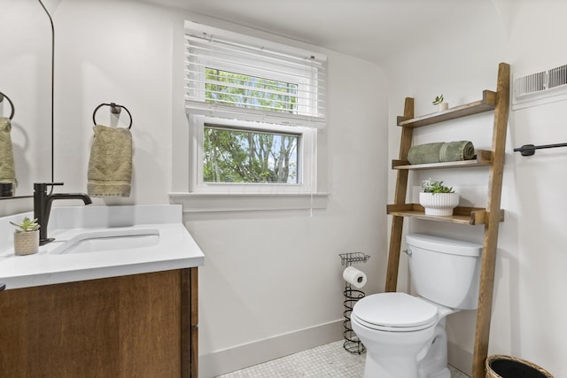 bathroom with toilet, vanity, and tile patterned floors