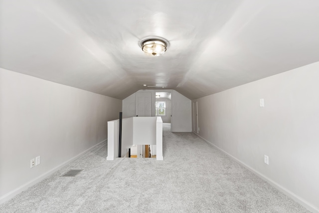 bonus room with light carpet and vaulted ceiling