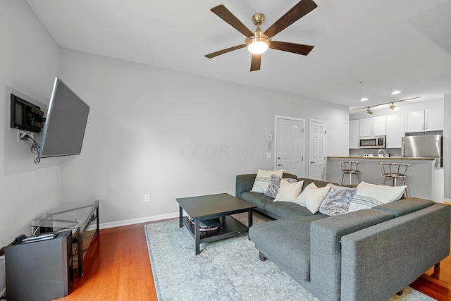 living room featuring hardwood / wood-style floors and ceiling fan