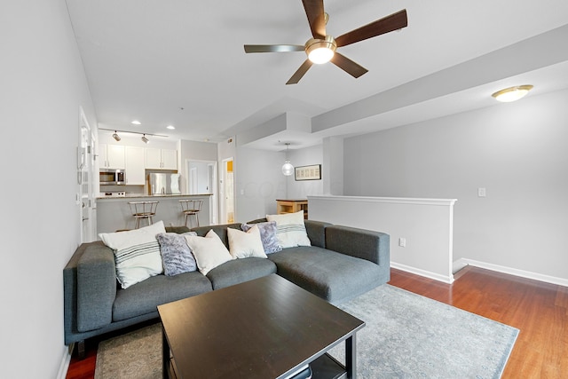 living room with ceiling fan and dark wood-type flooring