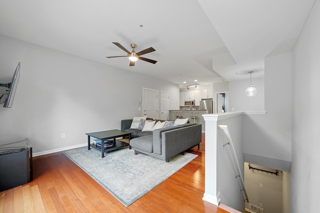 living room with ceiling fan and wood-type flooring