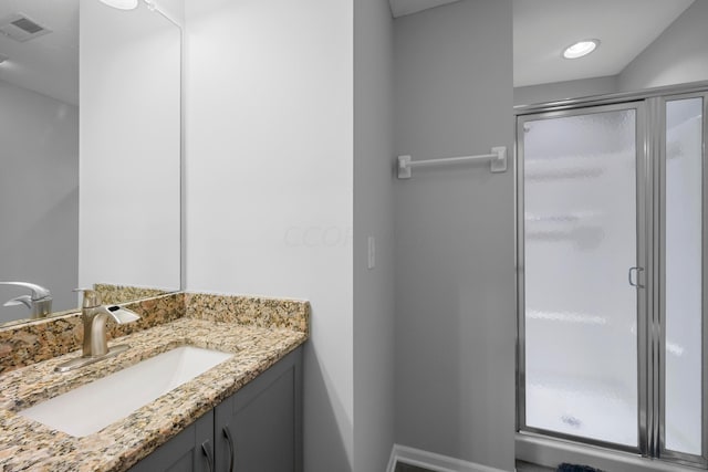 bathroom with vanity and a shower with door