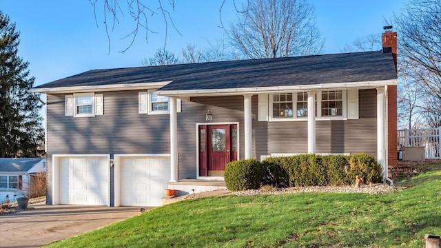 split foyer home with a garage and a front lawn